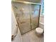 Bathroom shower with sliding glass doors and swan design at 7444 Candlelight Ct, New Port Richey, FL 34652