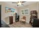 Bright bedroom with wood-look floors, ceiling fan, window with shutters and beach-themed decor at 8516 Wooddrift Dr, Tampa, FL 33615