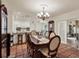 Sunlit dining room with chandelier and tiled floors leads to a sunroom through glass doors at 8516 Wooddrift Dr, Tampa, FL 33615