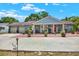 Inviting single-story home with a brick driveway, blue exterior, and well-maintained landscaping at 8516 Wooddrift Dr, Tampa, FL 33615