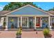Charming home featuring a brick porch, vibrant red door, decorative plants, and a quaint window seat at 8516 Wooddrift Dr, Tampa, FL 33615