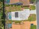 Overhead view featuring a large screened pool and solar panels on the roof with lush greenery at 9398 Mississippi Run, Weeki Wachee, FL 34613