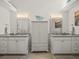 En suite bathroom with double vanities, plenty of lighting, and neutral color palette at 9398 Mississippi Run, Weeki Wachee, FL 34613