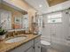 Well-lit bathroom with granite countertops, a large mirror, and a combined tub and shower at 9398 Mississippi Run, Weeki Wachee, FL 34613