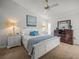 Bright bedroom with ceiling fan, white furniture, and accent pillows on the bed at 9398 Mississippi Run, Weeki Wachee, FL 34613