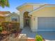 A well-maintained home showcasing lush landscaping, an arched entryway, and a modern, attached garage at 9398 Mississippi Run, Weeki Wachee, FL 34613