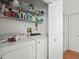 Functional laundry room with shelving for storage, including washer and dryer at 9398 Mississippi Run, Weeki Wachee, FL 34613