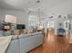Bright and airy living area features wood flooring, a ceiling fan, and seamless access to dining and kitchen spaces at 9398 Mississippi Run, Weeki Wachee, FL 34613