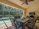Screened patio with a dining table, a pool view, and a tropical ceiling fan at 9398 Mississippi Run, Weeki Wachee, FL 34613