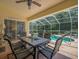 Screened patio with a dining table overlooking a pool and lush landscaping at 9398 Mississippi Run, Weeki Wachee, FL 34613