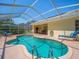 Relaxing screened-in pool with spacious outdoor patio, furniture, and manicured landscaping at 9398 Mississippi Run, Weeki Wachee, FL 34613