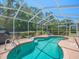 Inviting screened-in pool with a ladder, shallow tanning ledge, and a tranquil outdoor setting at 9398 Mississippi Run, Weeki Wachee, FL 34613