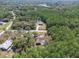 Aerial view of an estate-sized lot showcasing a house, a pool, and a surrounding dense forest at 10134 Buck Dr, New Port Richey, FL 34654