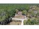 Aerial view of the home surrounded by a dense forest and a long driveway showcasing privacy and seclusion at 10134 Buck Dr, New Port Richey, FL 34654