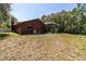 View of the home's backyard featuring a screened-in pool and an unkempt lawn at 10134 Buck Dr, New Port Richey, FL 34654