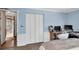 This bedroom features wood floors, a closet, baseboard trim, and an adjacent bathroom at 10134 Buck Dr, New Port Richey, FL 34654