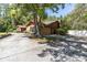 Side view of home with a two-car garage and mature tree providing shade at 10134 Buck Dr, New Port Richey, FL 34654