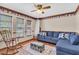 This cozy living room offers natural light, and features a ceiling fan and comfortable blue seating at 10134 Buck Dr, New Port Richey, FL 34654