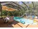 Screened-in pool featuring slide, umbrella, and chairs for backyard fun at 10134 Buck Dr, New Port Richey, FL 34654