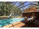 Screened-in pool area with waterslide, sun umbrella, and furniture at 10134 Buck Dr, New Port Richey, FL 34654