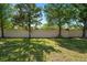 Large, grassy backyard enclosed by a white privacy fence and mature trees at 10780 43Rd N St # 702, Clearwater, FL 33762