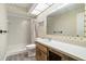 Bright bathroom featuring a walk-in shower, toilet, sink, and a vanity mirror at 10780 43Rd N St # 702, Clearwater, FL 33762