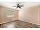 Bedroom with hardwood flooring and a large window with vertical blinds for privacy at 10780 43Rd N St # 702, Clearwater, FL 33762