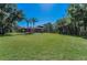 Expansive backyard features lush green grass, mature trees, and screened in patio at 10808 Alico Pass, New Port Richey, FL 34655