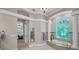 Luxurious bathroom with a soaking tub, tiled surround, large window, and elegant columns at 10808 Alico Pass, New Port Richey, FL 34655