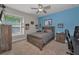 Bedroom features a bed with a wood frame, a ceiling fan and large window with natural light at 10808 Alico Pass, New Port Richey, FL 34655