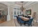 An elegant dining space has a statement chandelier and large windows offering ample natural light at 10808 Alico Pass, New Port Richey, FL 34655