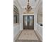 Elegant foyer with a decorative chandelier, glass door, and arched entrance that enhances the welcoming ambiance at 10808 Alico Pass, New Port Richey, FL 34655