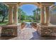 Welcoming front entrance with stone columns and a beautiful view of the house, set amidst landscaped grounds at 10808 Alico Pass, New Port Richey, FL 34655