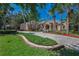 Stately home with lush landscaping, a circular driveway and mature palm trees at 10808 Alico Pass, New Port Richey, FL 34655