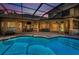 A stunning outdoor space features a sparkling pool, covered patio, and scenic views overlooking an outdoor fireplace at 10808 Alico Pass, New Port Richey, FL 34655