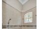 Bathroom shower features tiled walls, decorative trim, and chrome shower head fixture at 10808 Alico Pass, New Port Richey, FL 34655