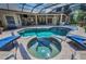 This stunning in-ground pool features a spa and plenty of seating inside a screened enclosure for comfort and leisure at 10808 Alico Pass, New Port Richey, FL 34655