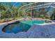 A luxurious pool with a spa and lounge chairs is featured within a screened enclosure for ultimate relaxation at 10808 Alico Pass, New Port Richey, FL 34655