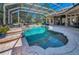 A sparkling swimming pool surrounded by patio space inside a screened enclosure, offering relaxation and recreation at 10808 Alico Pass, New Port Richey, FL 34655