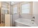 Bathroom features tub with tile surround and glass shower at 11254 Mollymawk Ct, New Port Richey, FL 34654