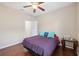 Bedroom with hardwood floors, ceiling fan, and comfortable bed next to small wooden table at 11254 Mollymawk Ct, New Port Richey, FL 34654