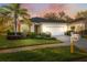 Inviting single-story home featuring a well-manicured lawn, mature palm tree, and a two-car garage at 11254 Mollymawk Ct, New Port Richey, FL 34654
