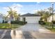 Charming single-story home with well-kept landscaping, a mature palm tree, and a spacious driveway leading to a two-car garage at 11254 Mollymawk Ct, New Port Richey, FL 34654