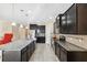 Large kitchen with dark wood cabinets, granite countertops, stainless steel appliances and center island with sink at 11254 Mollymawk Ct, New Port Richey, FL 34654