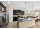 Open concept kitchen with a large island, dark wood cabinets, stainless steel appliances, and a dining area at 11254 Mollymawk Ct, New Port Richey, FL 34654