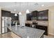 Spacious kitchen features dark wood cabinets, stainless steel appliances, granite countertops, and a large island at 11254 Mollymawk Ct, New Port Richey, FL 34654