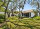 Lush backyard with mature trees and view of the back of the home at 11536 Golden Rain Dr, New Port Richey, FL 34654