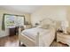 Cozy bedroom featuring a white bed frame, wooden floors, and natural light from the window at 11536 Golden Rain Dr, New Port Richey, FL 34654