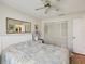 Bedroom featuring wood floors, a ceiling fan and double-door closet providing ample storage space at 11536 Golden Rain Dr, New Port Richey, FL 34654