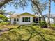 Charming home exterior with lush green lawn and mature trees providing shade and curb appeal at 11536 Golden Rain Dr, New Port Richey, FL 34654